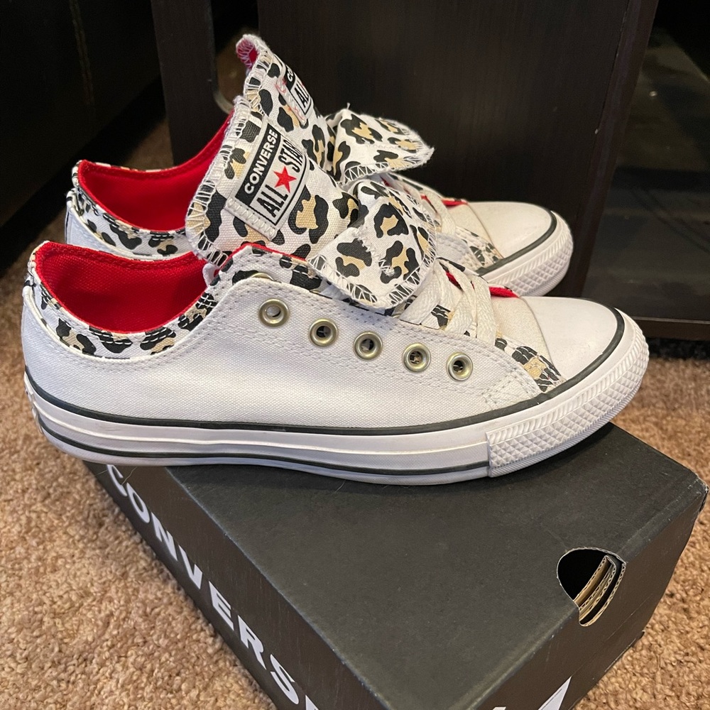 Double lined white and cheetah converse with red accents.